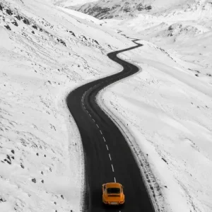 Porsche orange Winter Berge Schnee schwarz weiss